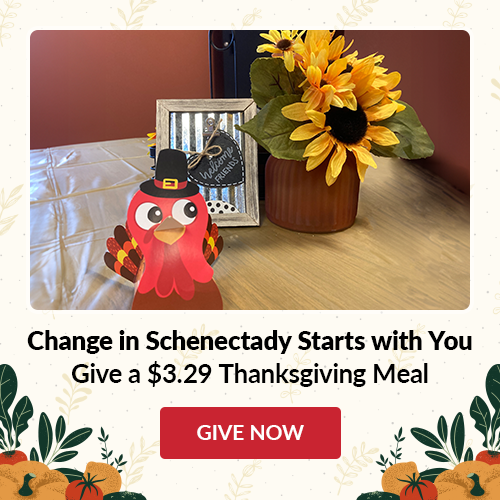 Image of a placesetting for Thanksgiving with wording under stating Changne in Schenectady starts with you Give a $3.29 Thanksgiving Meal