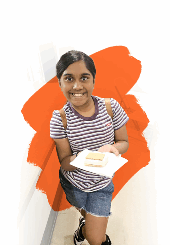 Young girl with backpack holding a s'more